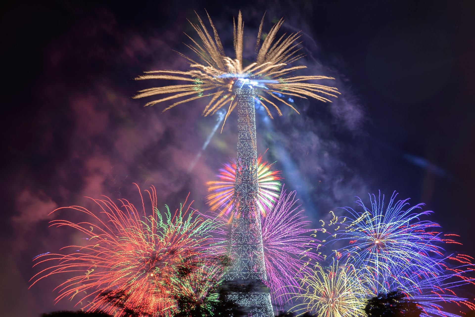 Eiffel Tower lit with colorful fireworks for Bastille Day