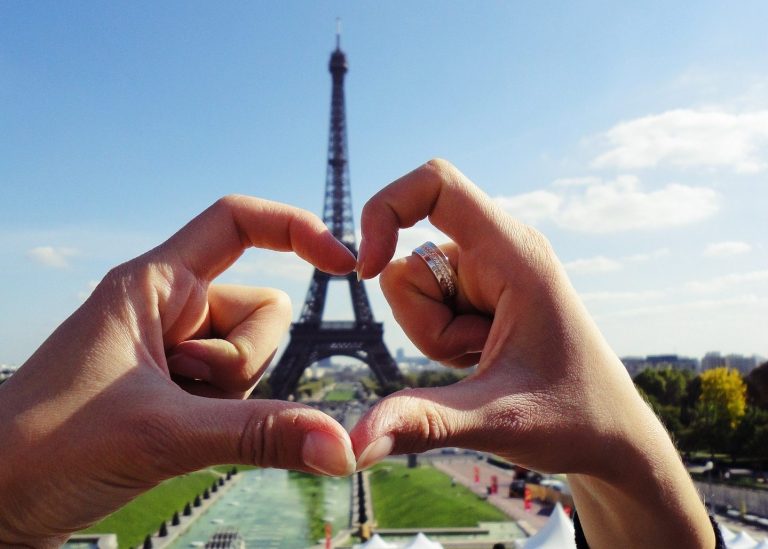 Heart shaped hands around the Eiffel Tower in Paris